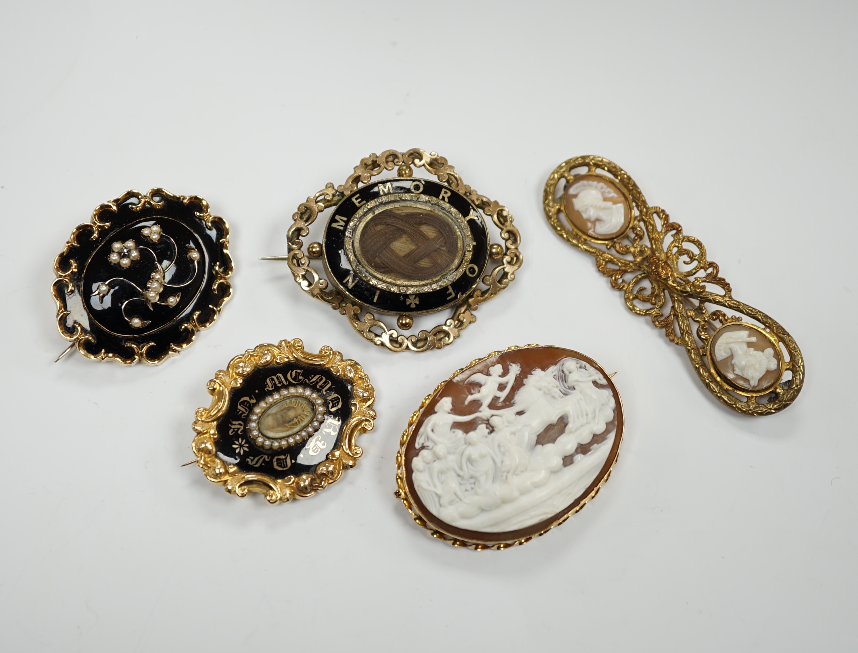 Three assorted Victorian mourning brooches, including two yellow metal, one set with seed pearls and diamond chip and inscribed and dated 1847, 48mm and two cameo shell set brooches.